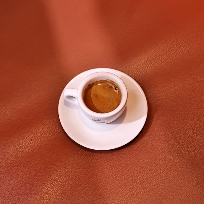 Café arabe dans une petite tasse avec des grains de café.