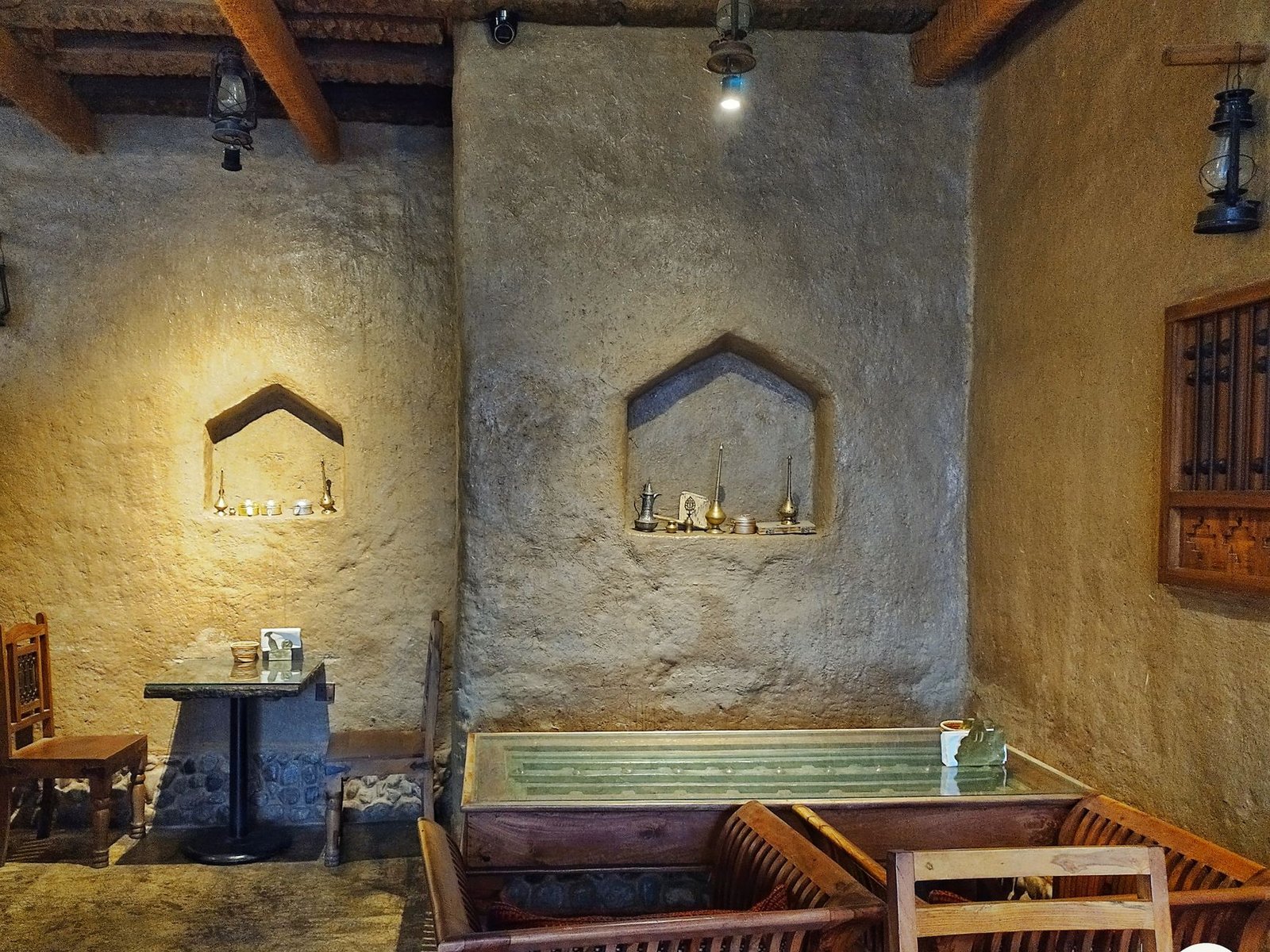 Intérieur chaleureux d'un café avec sièges confortables et lanternes.